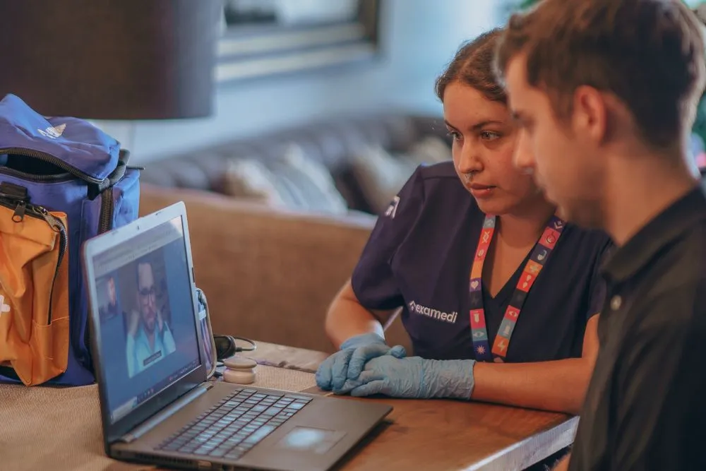 Paciente realizando consulta virtual online desde computador para atención médica a distancia con profesional certificado